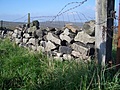 Dry stone wall with barbed wire