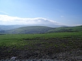 Muddy field and green hill