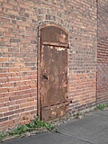 Rusty metal door in a brick wall