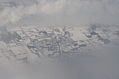 Snow-covered fields seen through clouds 13