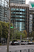Scrawny tree, curved skyscraper