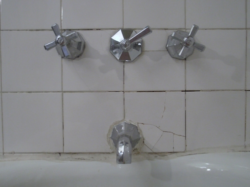 [Picture: Faucets and cracked tiles]