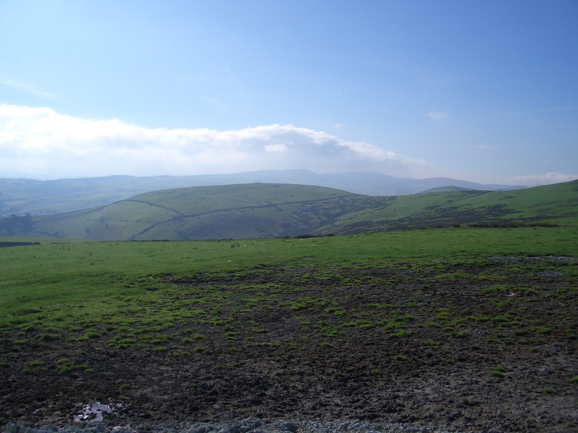 [Picture: Muddy field and green hill]