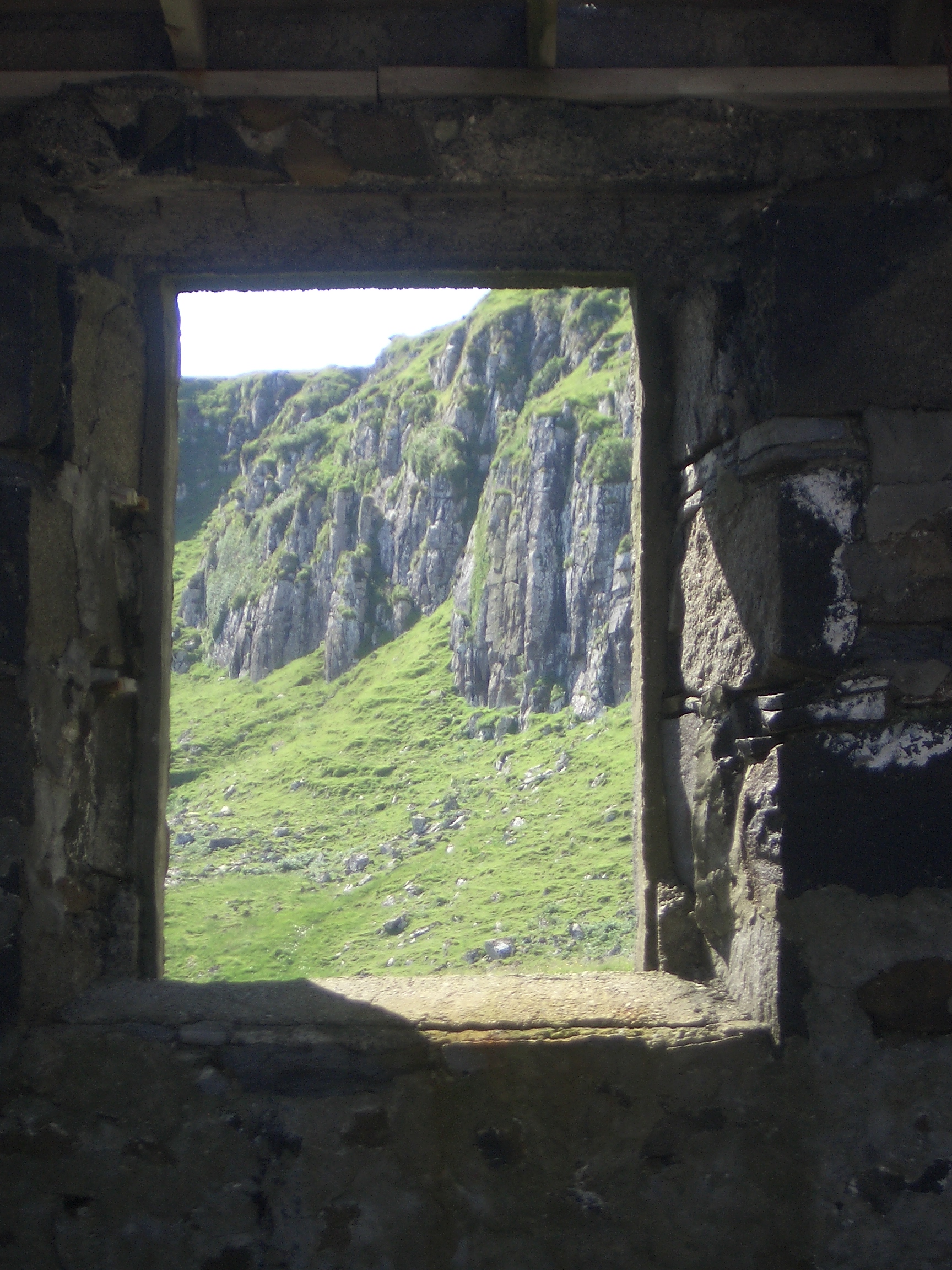 [Picture: Cliff seen though old window]