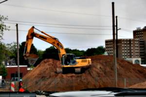 [Picture: mechanical digger on a mound]