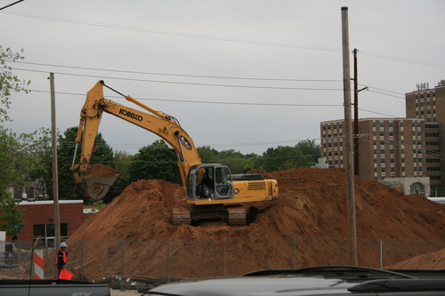 [Picture: mechanical digger on a mound]