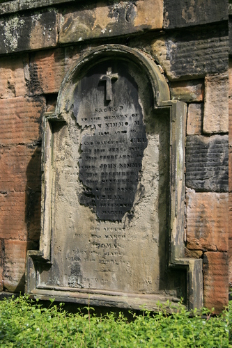 [Picture: Weathered gravestone set into old stone wall]