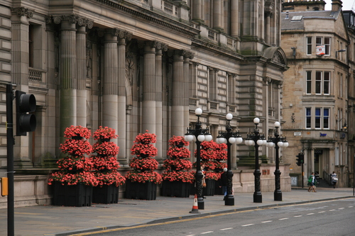 [Picture: Neoclassical entrance with carefully manicured flowers]