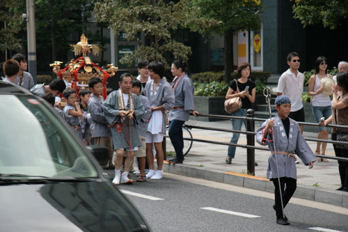 [Picture: Child with staff leading the mikoshi]